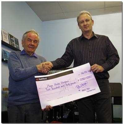 Arthur Newnes (left) receiving the cheque on behalf of Hope House from Menai Bridge Band Chairman, Brian Mottershead 